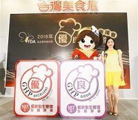 台灣美食展昨登場，食藥署設攤宣傳食品衛生安全，署長吳秀梅（右）介紹GHP餐飲衛生管理分級評核制度優良標章。
