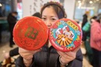 春節近 特色年貨搶市 大陸和台灣的青年創業者在南京江寧共建「番鴨市集」，為當地民眾帶來特色年貨。圖為台灣青年展示文創產品。（中新社）
